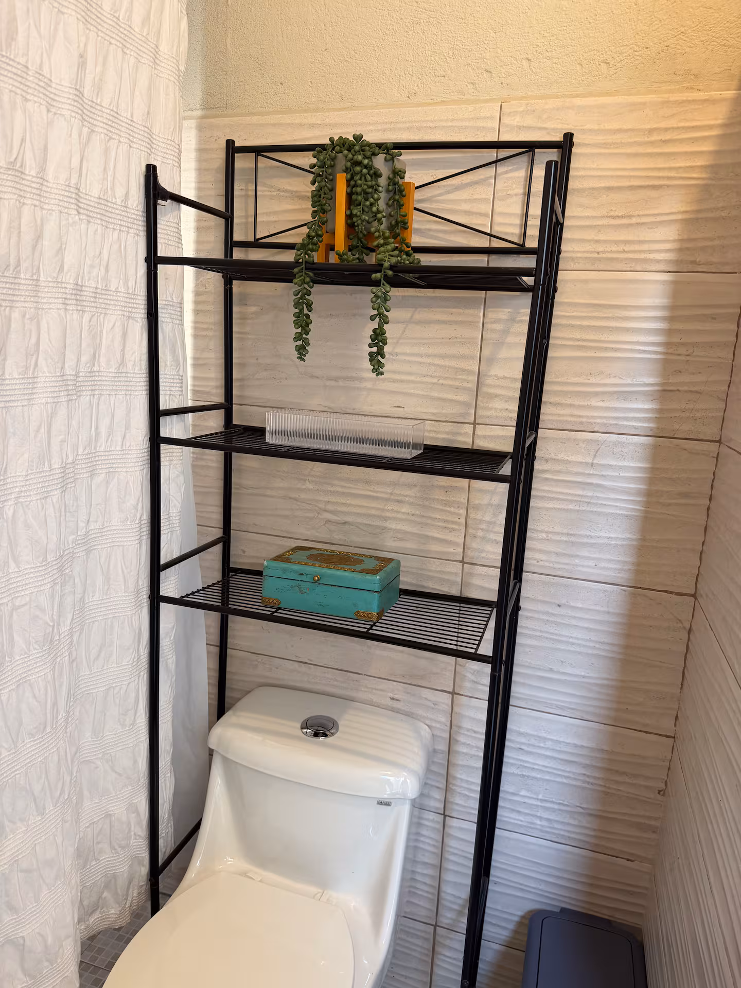 Baño con regadera y repisas de almacenamiento
